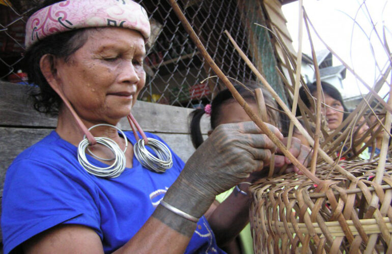 Photograph of a local woman basket weaving.