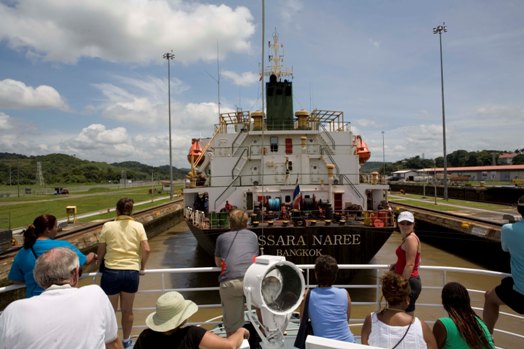 PANAMA CANAL, PANAMA, JULY 15, 2006: Passengers on the Pacific Queen, a ship taking passengers throught the Panama Canal, watch as they rise 26 feet in the Miraflores Locks along with a cargo ship from Bangkok, before continuing their journey to the Atlantic via two more Locks, in the Panama Canal, Panama, July 15, 2006 (photo by Gilles Mingasson/Getty Images for National Geographic).